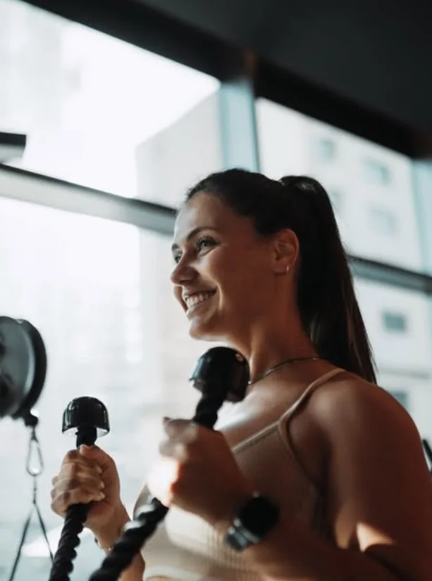 Treinadora a sorrir durante um exercício com cordas